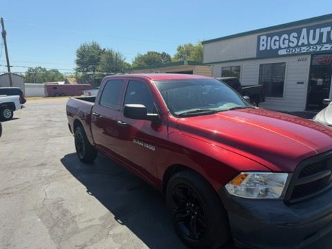 Red pickup truck parked outside a Biggs Auto dealership on a sunny day