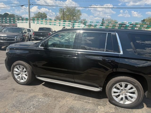 Black SUV parked in a lot under a partly cloudy sky