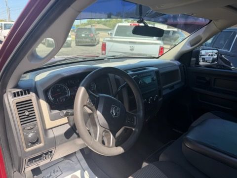 View from the driver’s seat of a beige car interior, showing the steering wheel and dashboard in daylight.