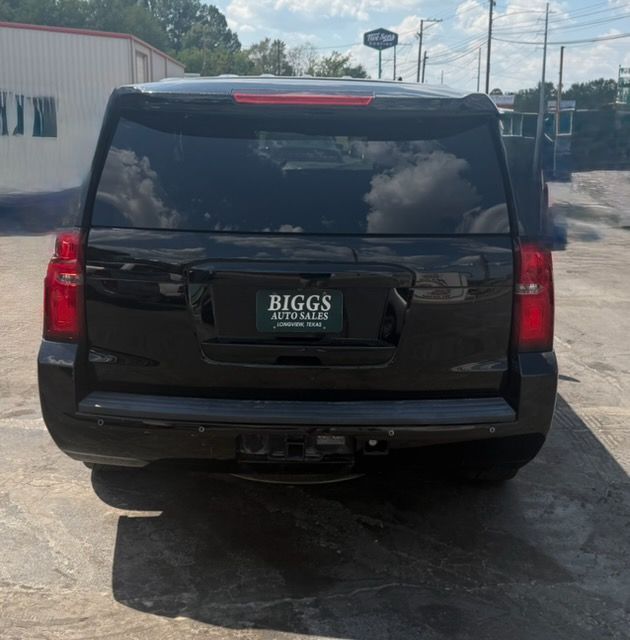 Rear view of a black SUV parked outdoors with a BIGGS license plate frame