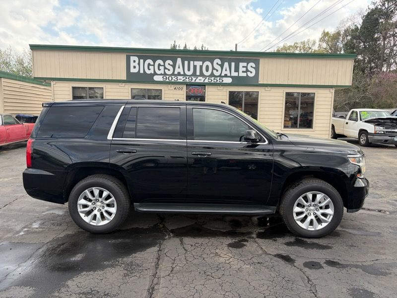 Black SUV parked in front of Biggs Auto Sales dealership on a wet lot