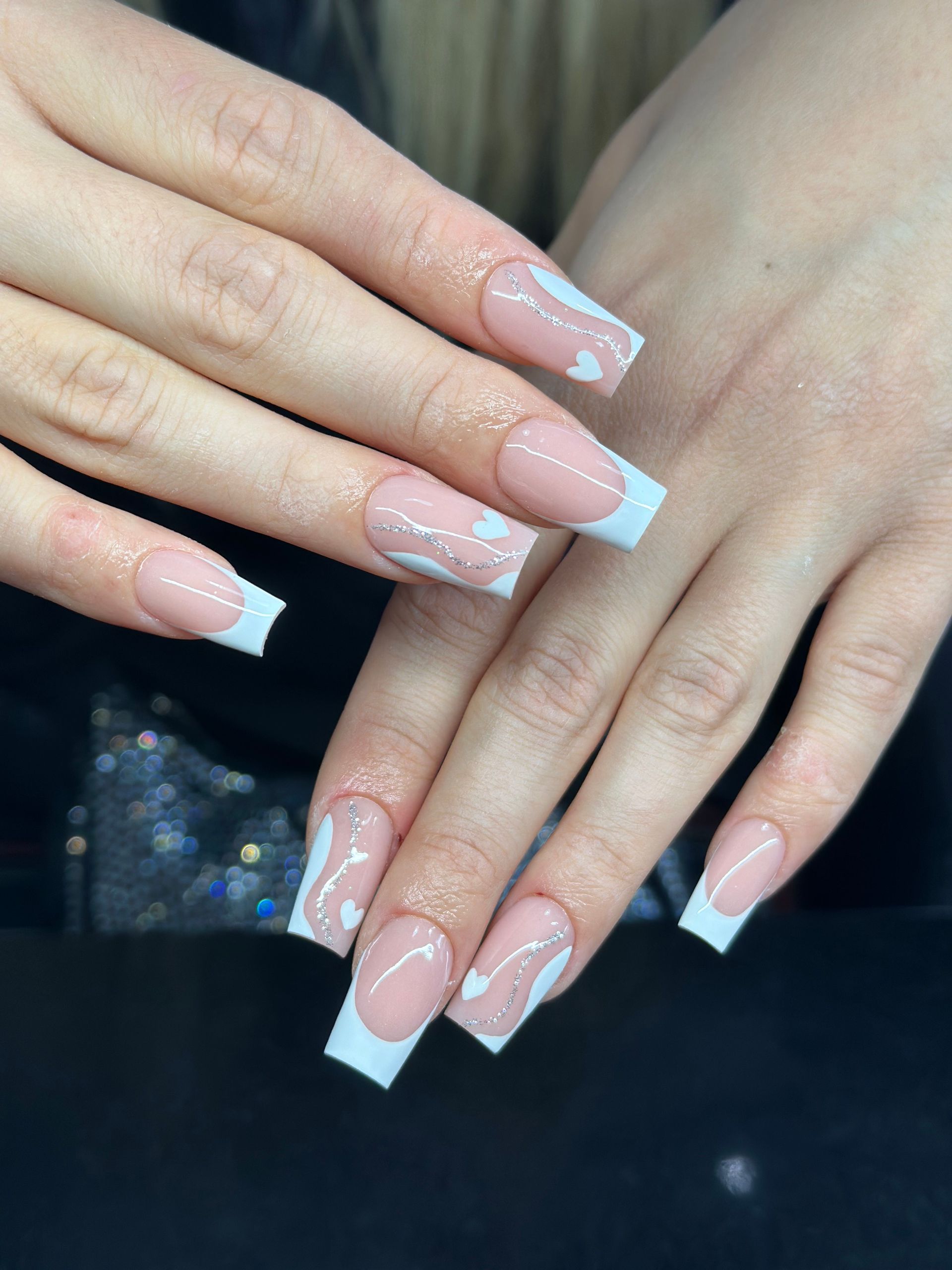 Eine Nahaufnahme der Nägel einer Frau mit einer French Manicure.