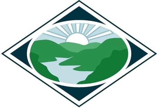 Stylized green mountains and river inside a diamond-shaped logo with a rising sun