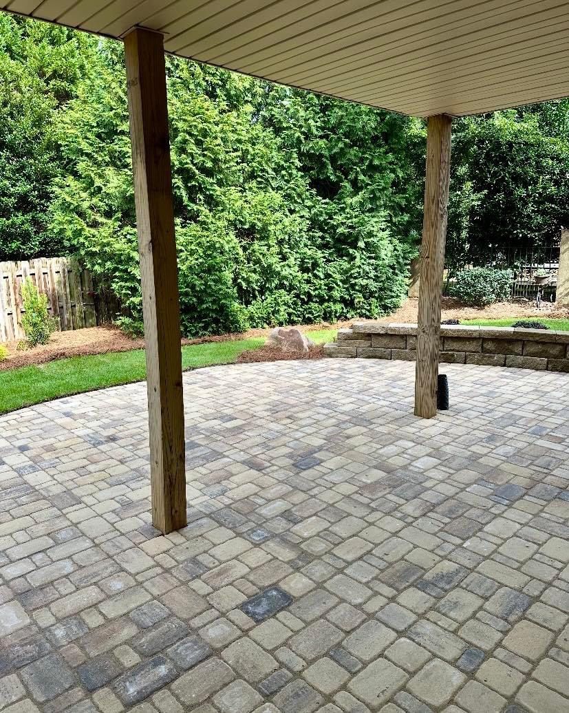 A patio with a covered area and trees in the background.
