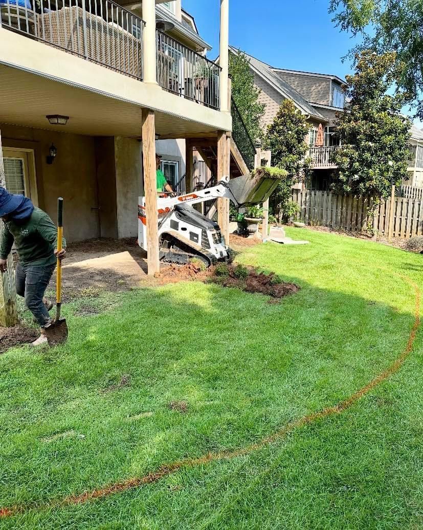 A man is digging in the grass in front of a house.