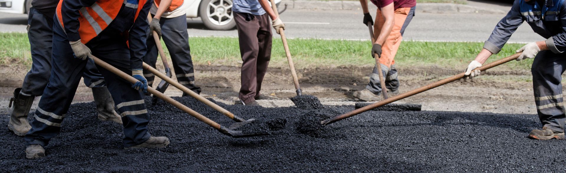 Road workers laying asphalt. Road workers laying asphalt.