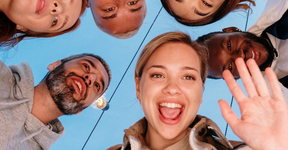 A group of people are standing in a circle looking down at the camera.