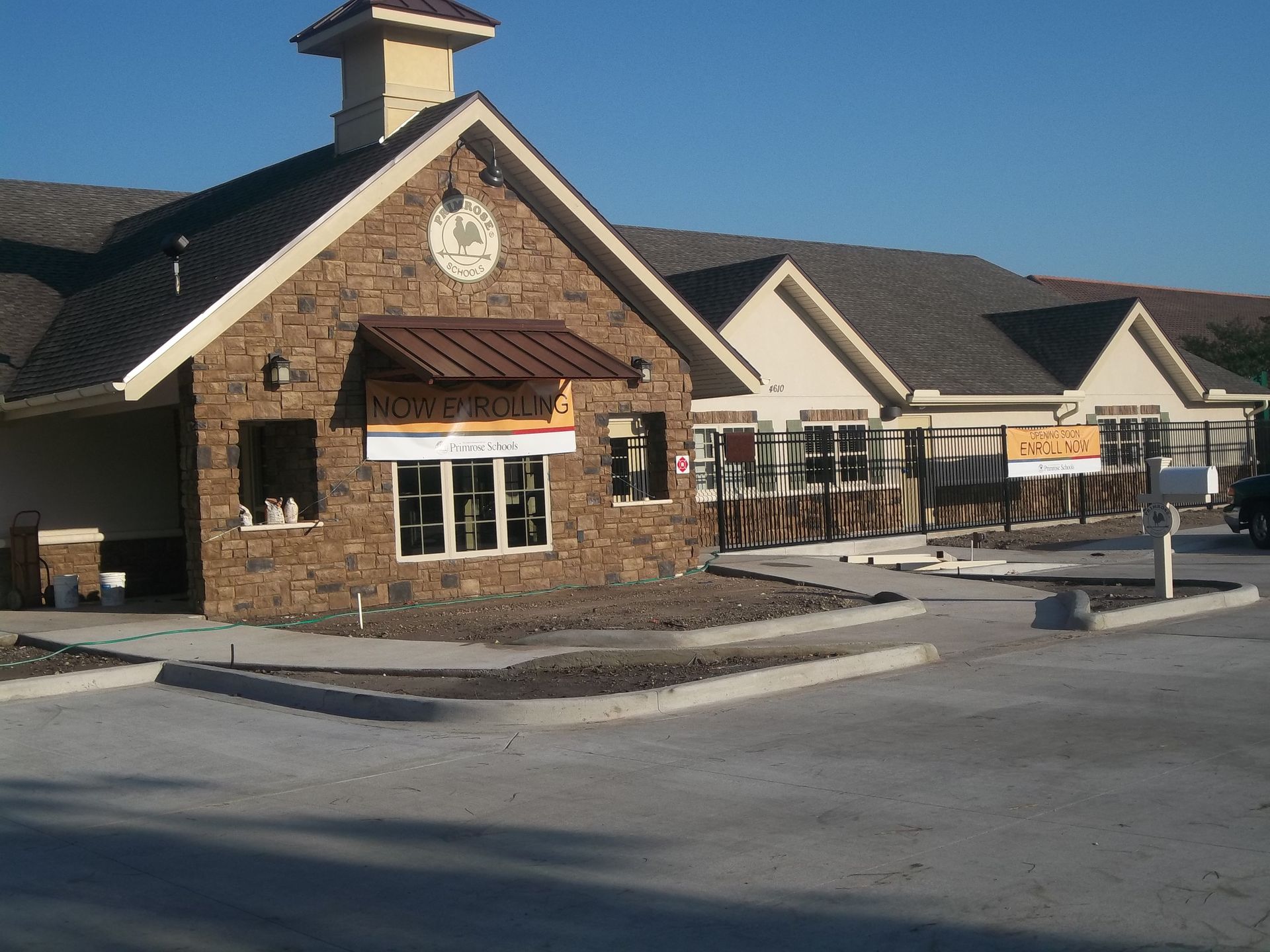 Stone building with brown awning and drive-through, sunny exterior.