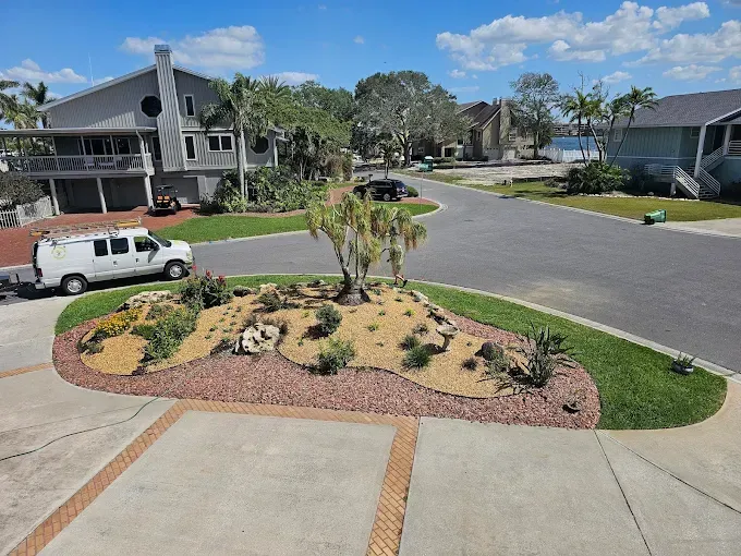 Suburban cul-de-sac with landscaped median, parked white van, and two-story homes on a sunny day