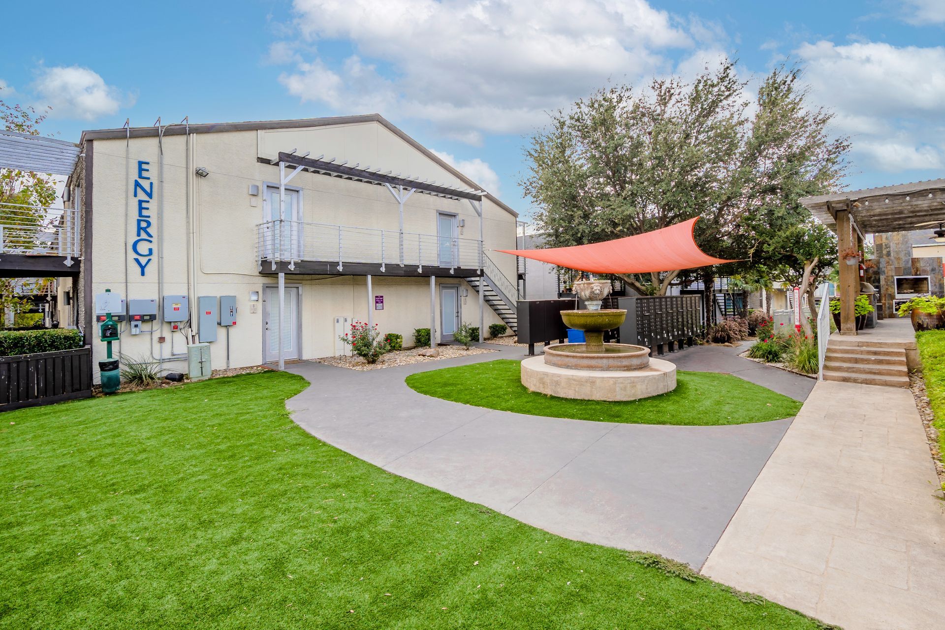 Photo of a two-story building, showing back exits and a lawn-type of area