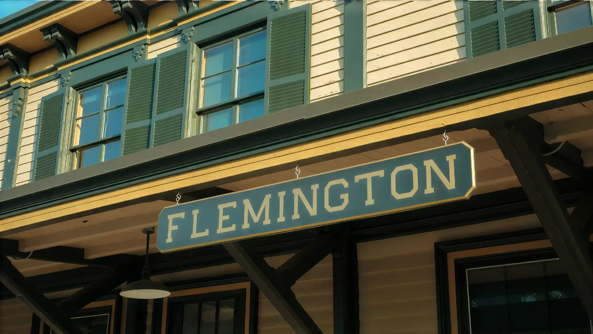 Flemington sign on a historic building with green-trimmed windows and a covered porch