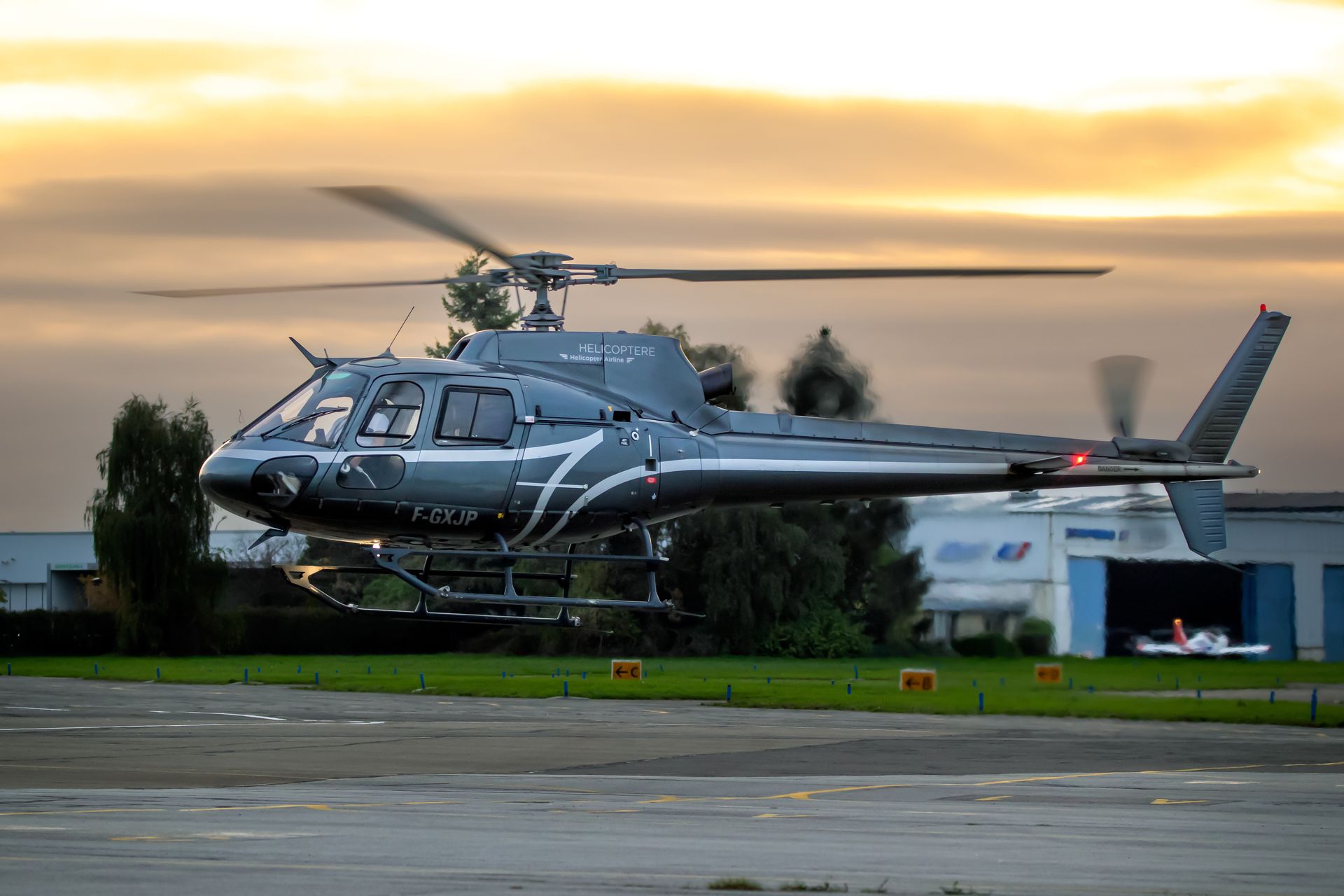 Helicopter with black and white paint scheme against a clear blue sky.