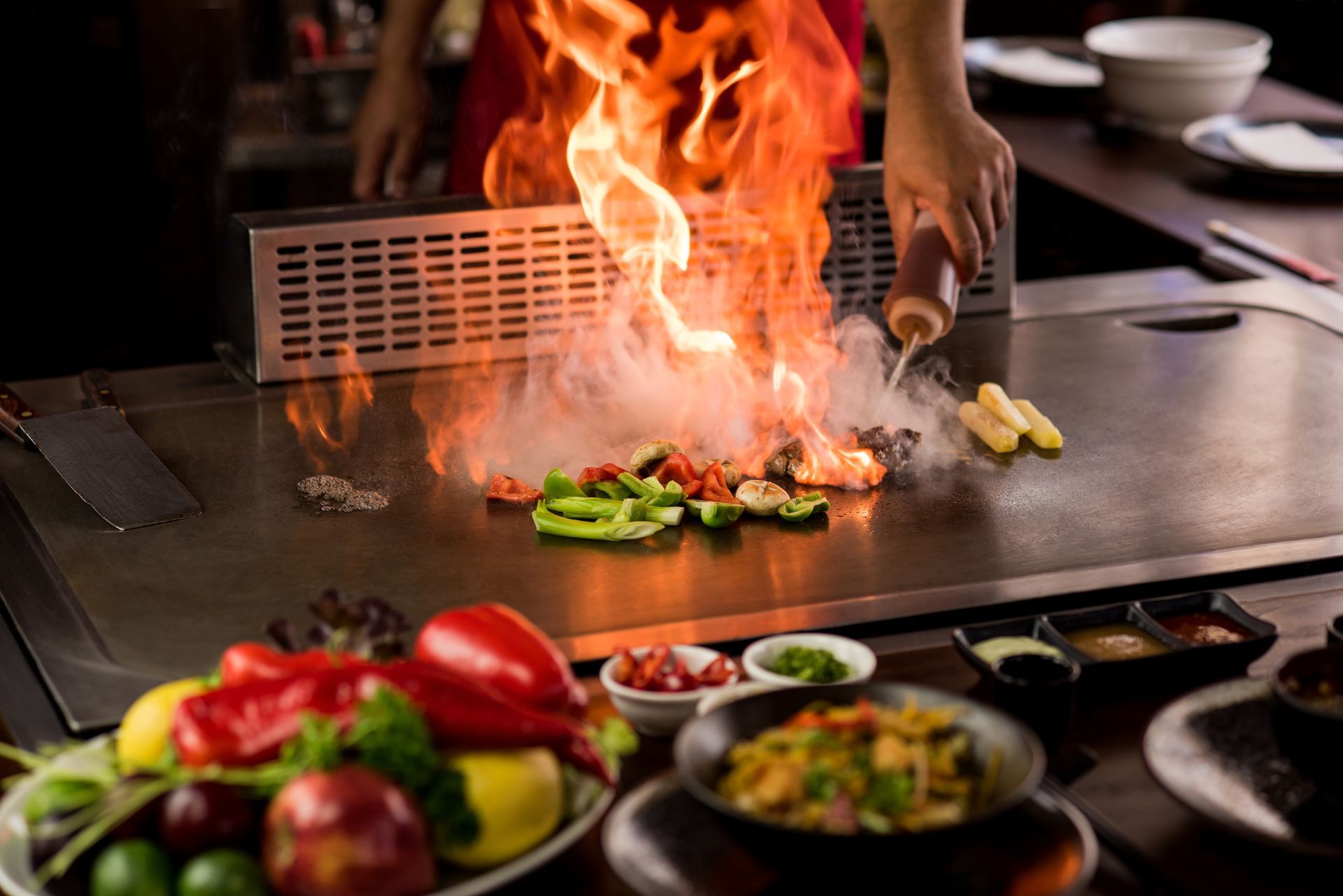 Eine Person bereitet Essen auf einer Grillplatte in einem Restaurant .