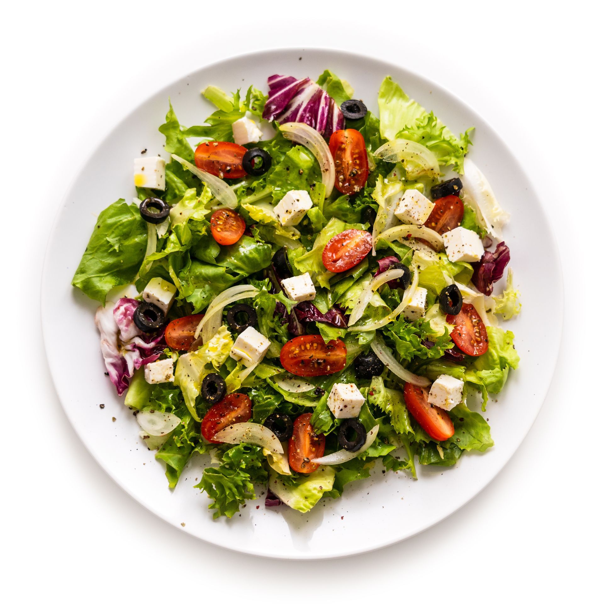 Auf einem weißen Teller steht ein Salat mit Tomaten , Oliven , Feta und Salat .