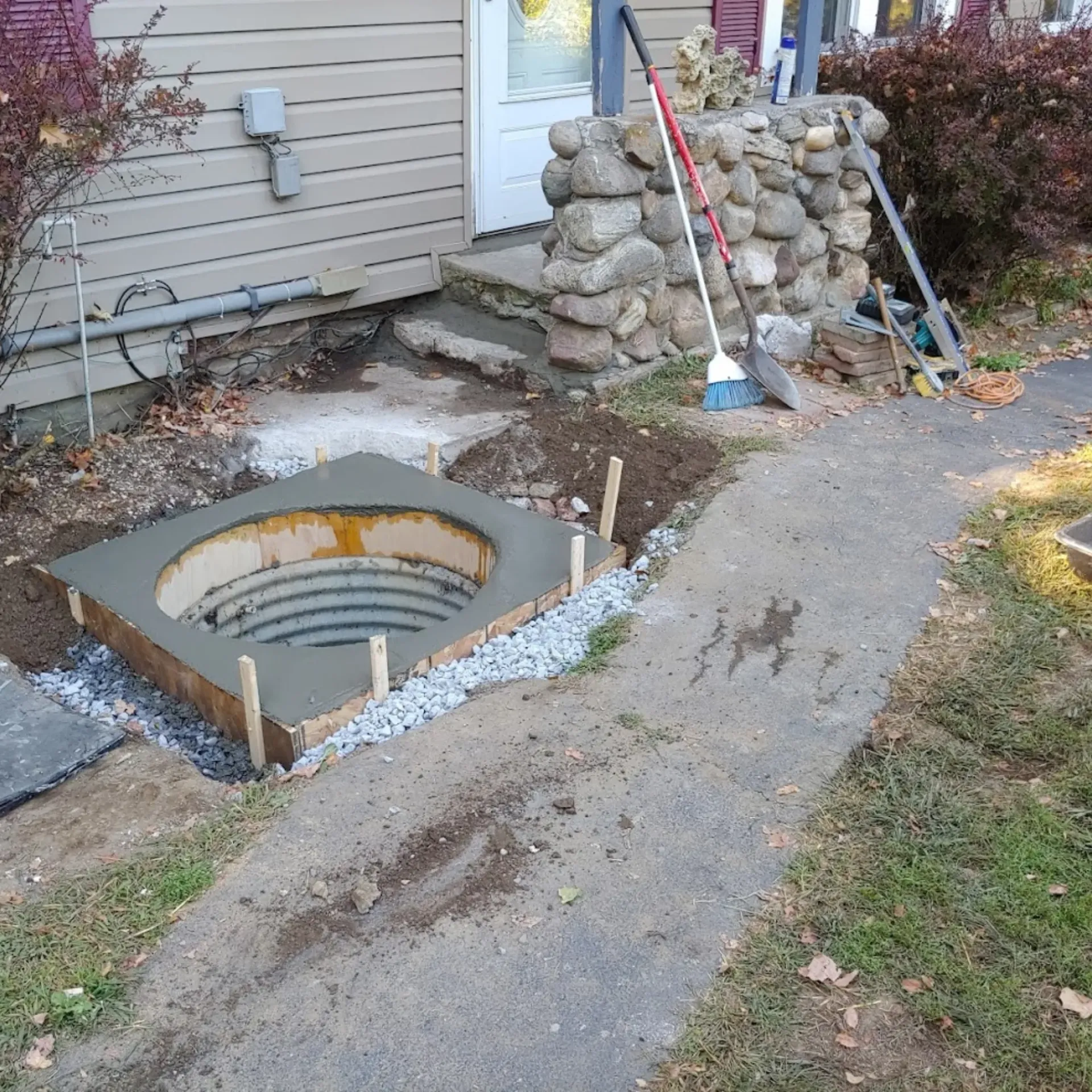 CK Maintenance LLC - A manhole cover is being built in front of a house