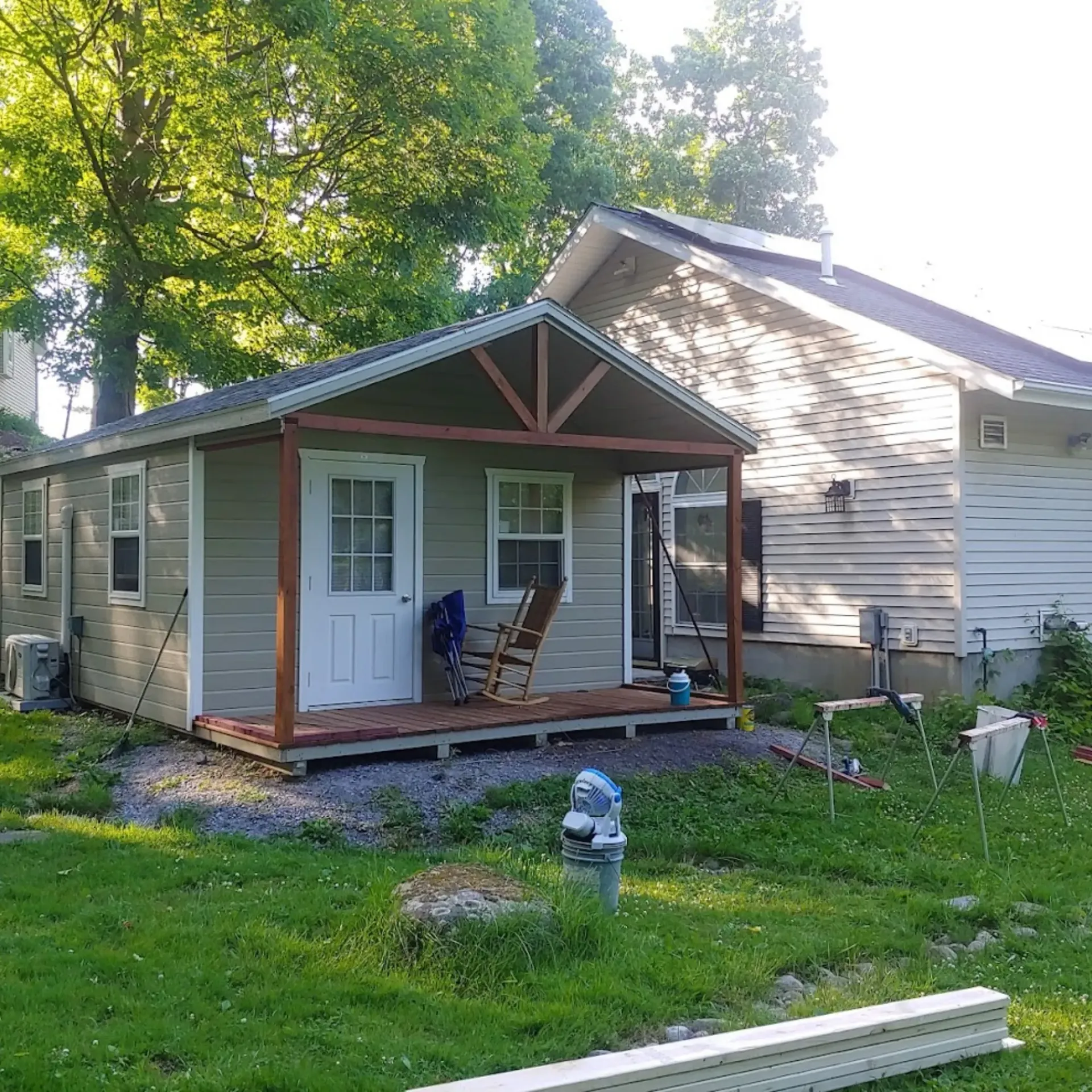 CK Maintenance LLC - A small house with a porch and chairs in front of it.