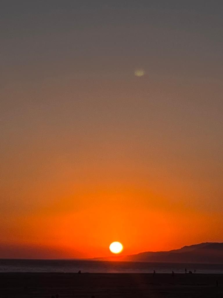 Zonsondergang met zon en maan