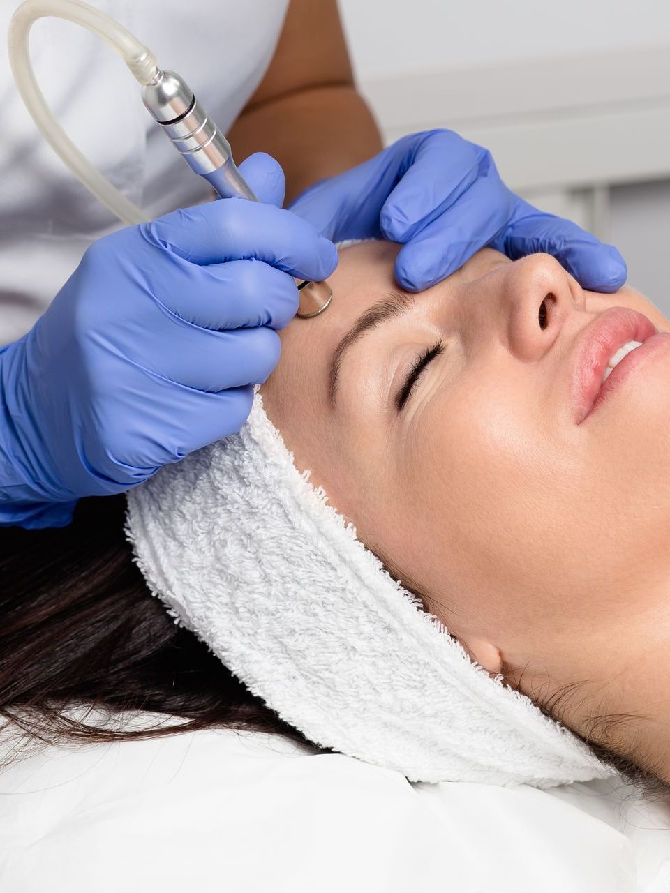 A woman is getting a facial treatment at a beauty salon.