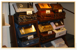 Display of ornate wooden cigar humidors on shelves.