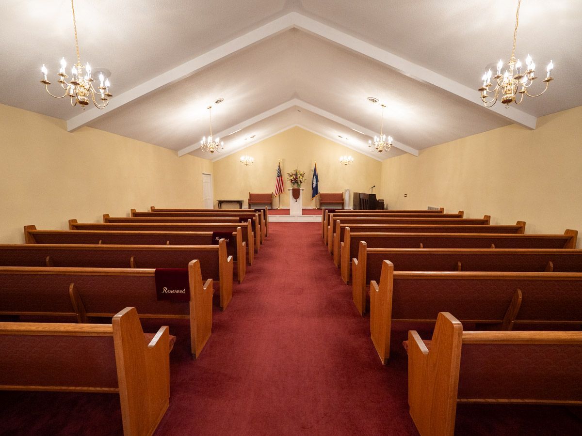 Casket display room with multiple open and closed caskets, various colors.
