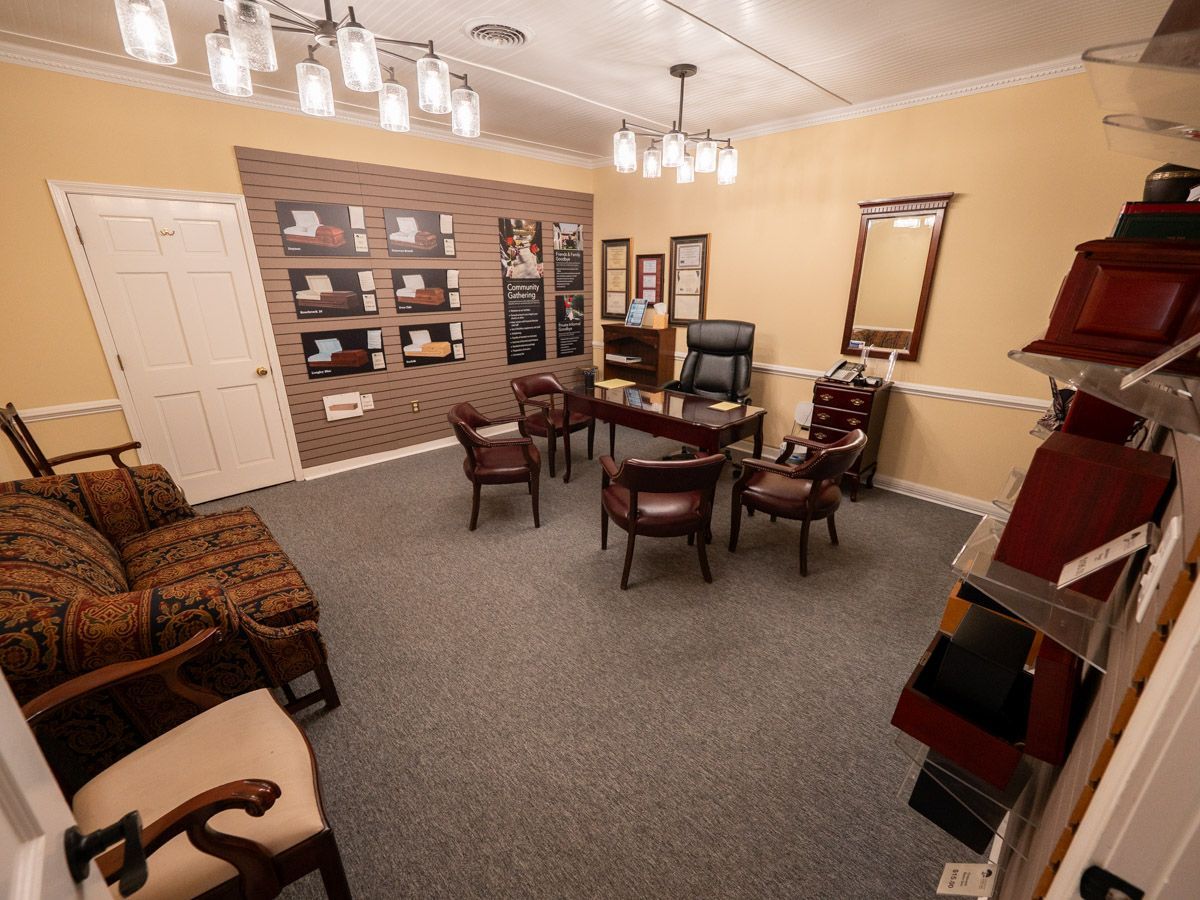 Dark wooden shelves displaying various cremation urns and keepsakes in a room with a red carpet.