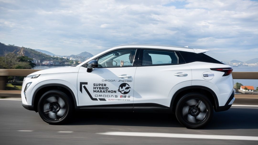 Um SUV elétrico branco estacionado contra um fundo de padrões de circuitos digitais brilhantes em azul e verde.