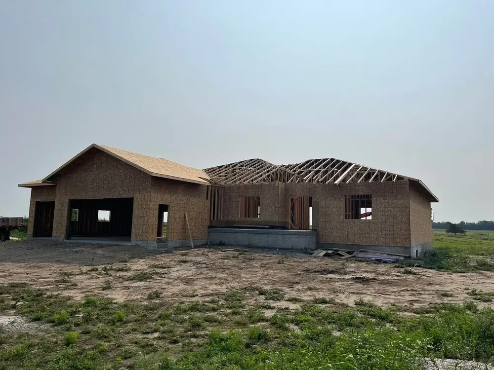 A house is being built in the middle of a field.