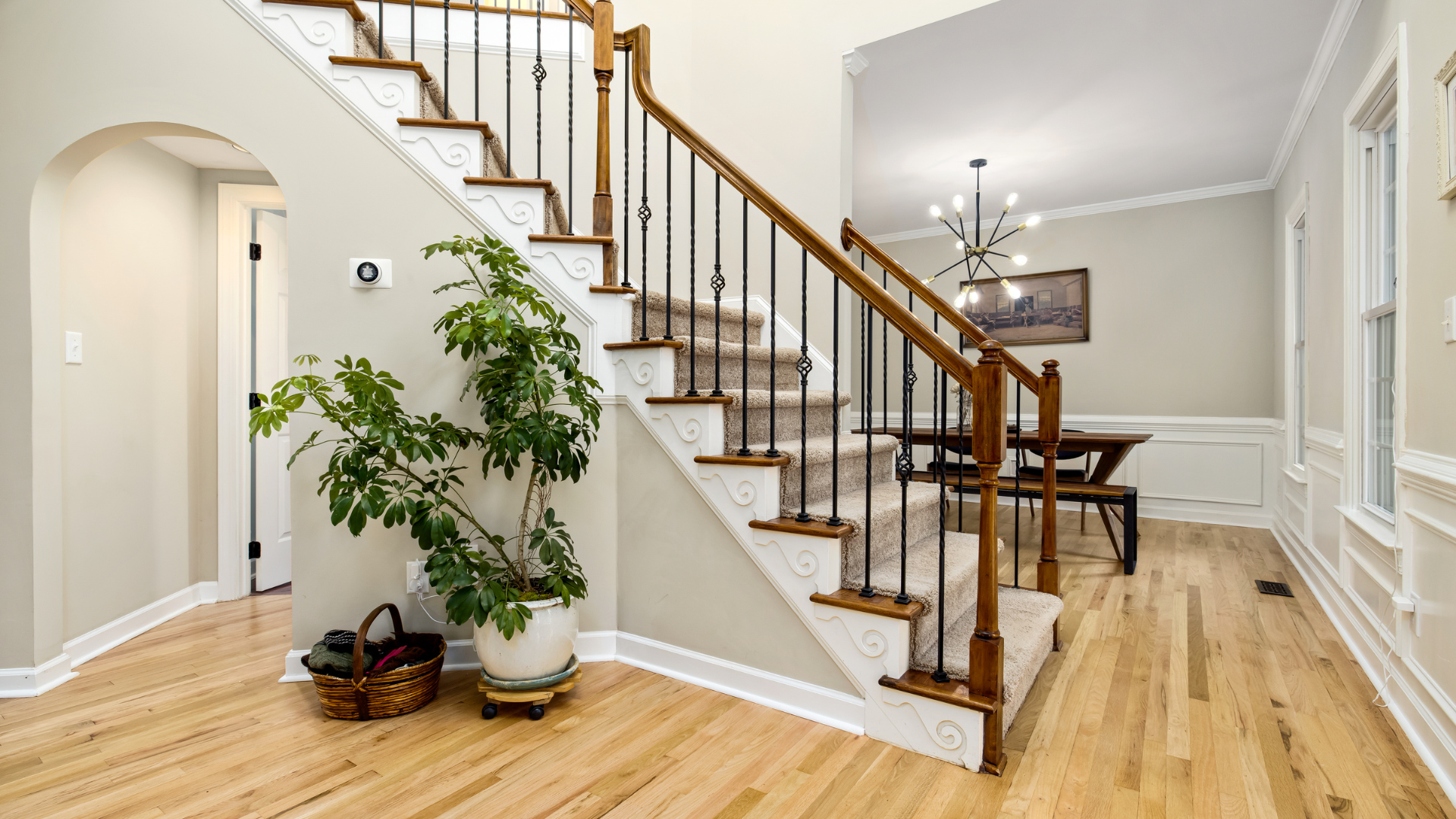 Wooden front door in a small hallway with light walls and wood flooring.