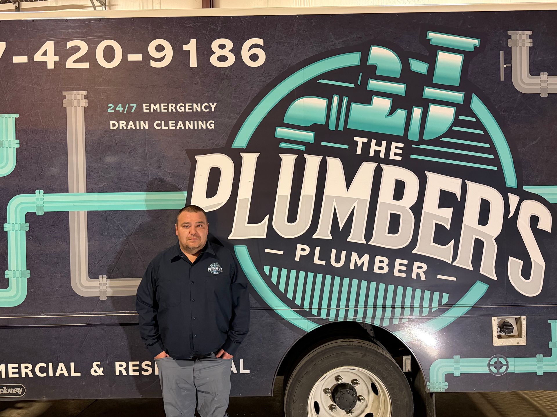 Man in work attire stands next to a van with