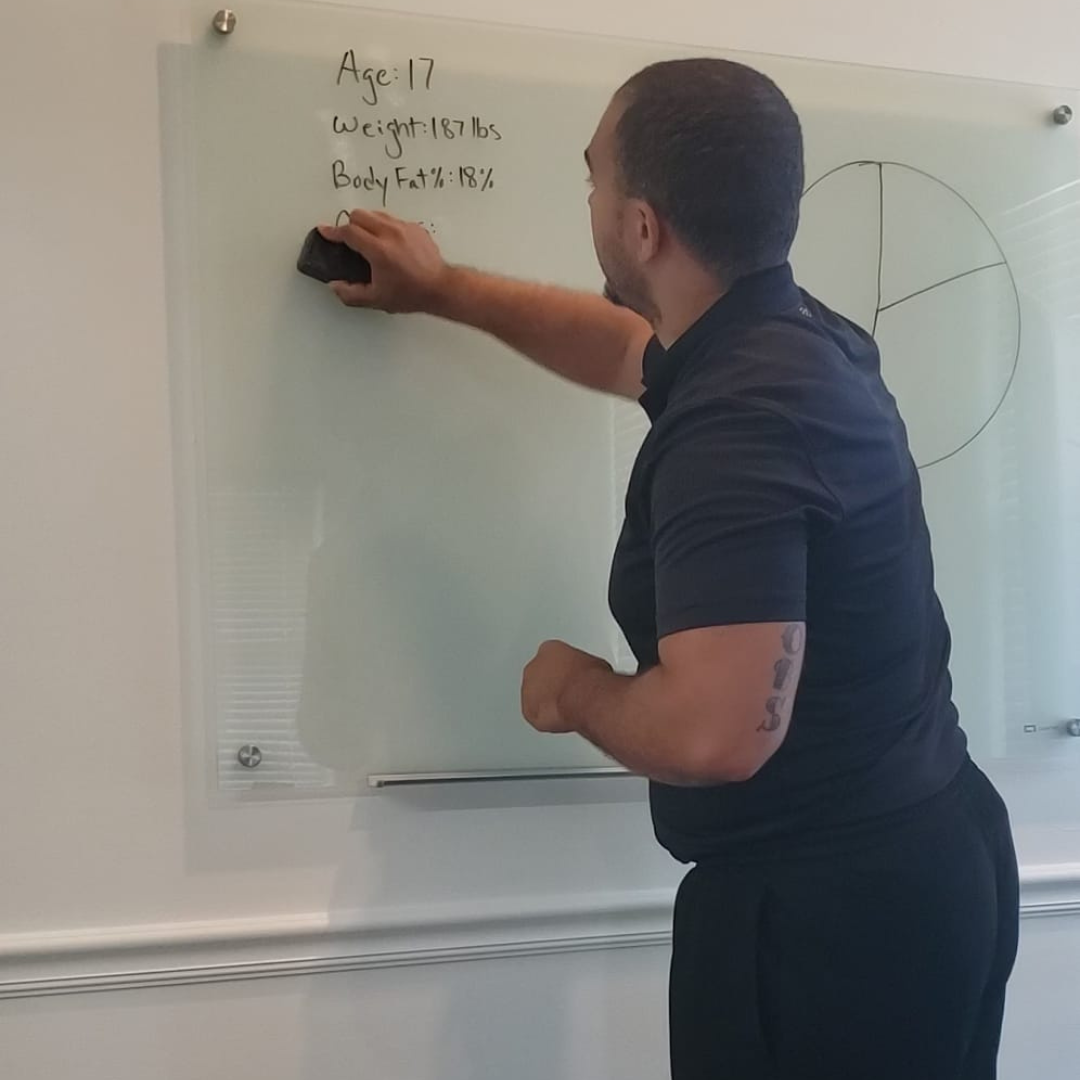 A man is writing on a whiteboard.