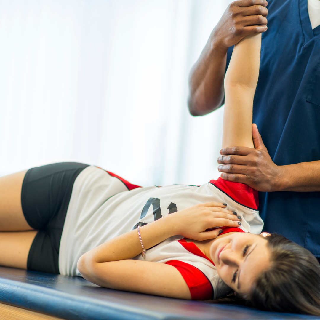 A women is getting her shoulder stretched.