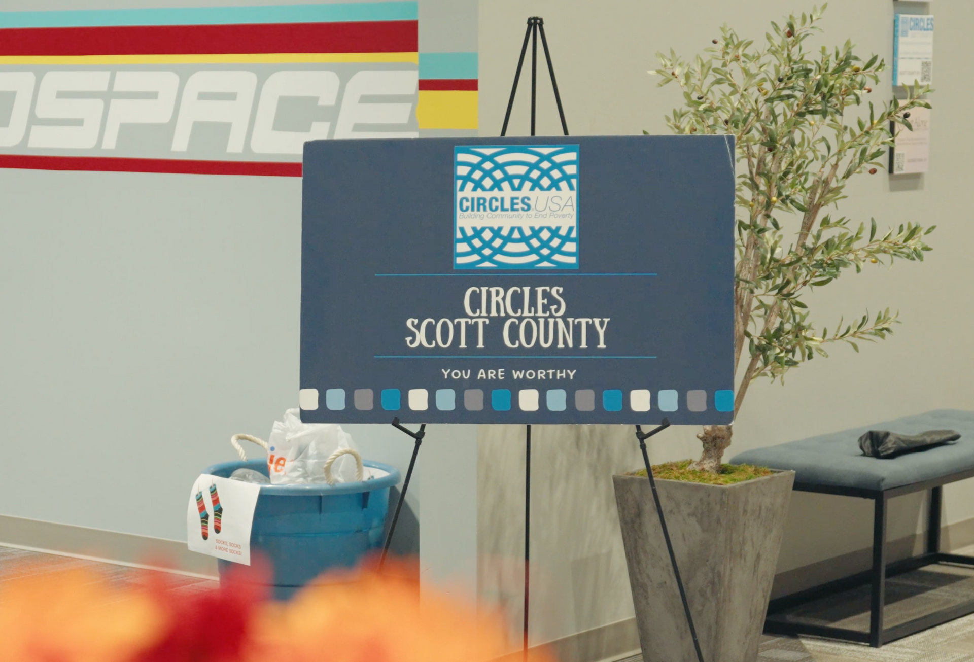 Sign for Circles Scott County at an event. Blue and white logo, standing on an easel.