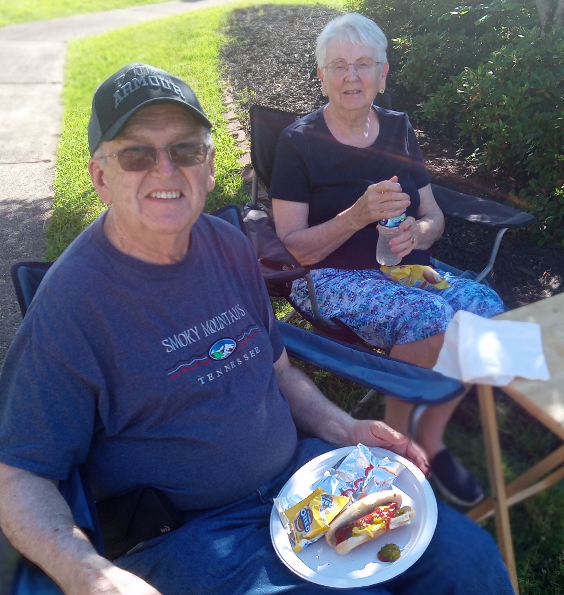 A man wearing a shirt that says sunny harbor is sitting next to a woman