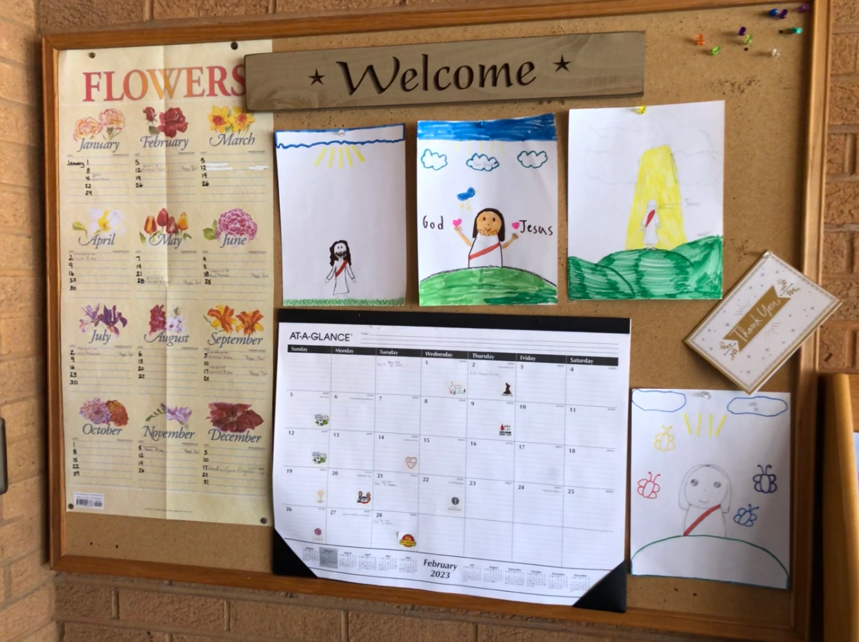 A bulletin board with flowers and welcome written on it