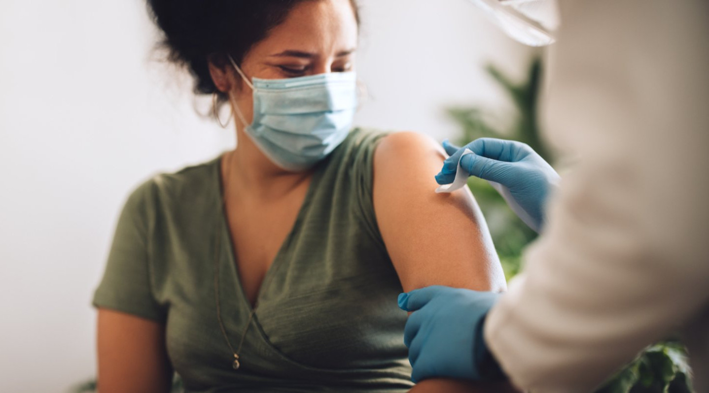 woman prepares for vaccine injection in shoulder