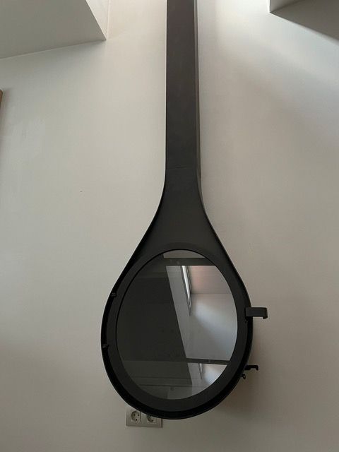 Un espejo colgado del techo con el reflejo de una habitación.