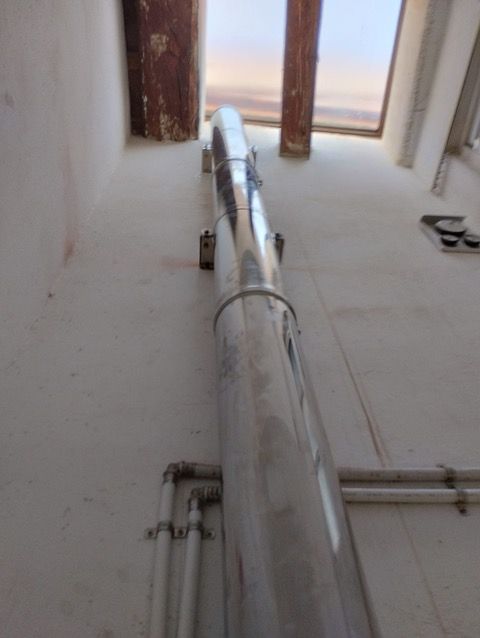 Un tubo de acero inoxidable cuelga del techo de un edificio.