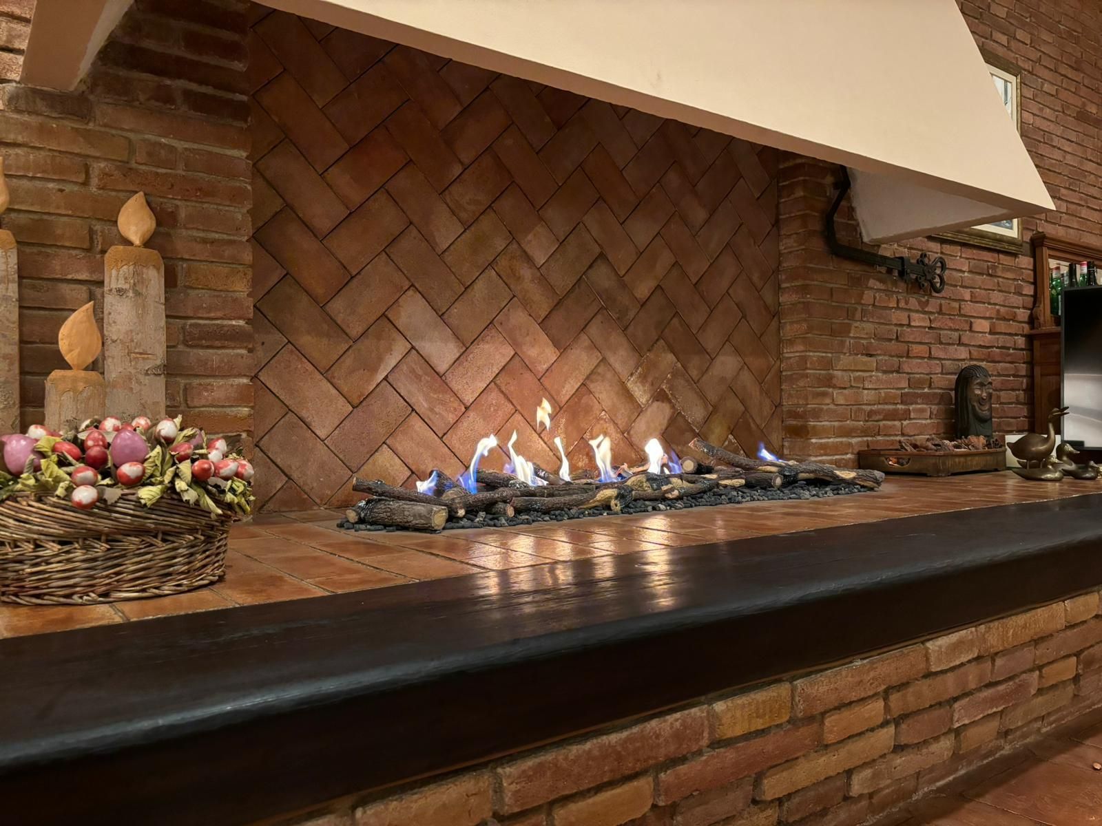 Una chimenea en una cocina con una cesta de flores en el mostrador.