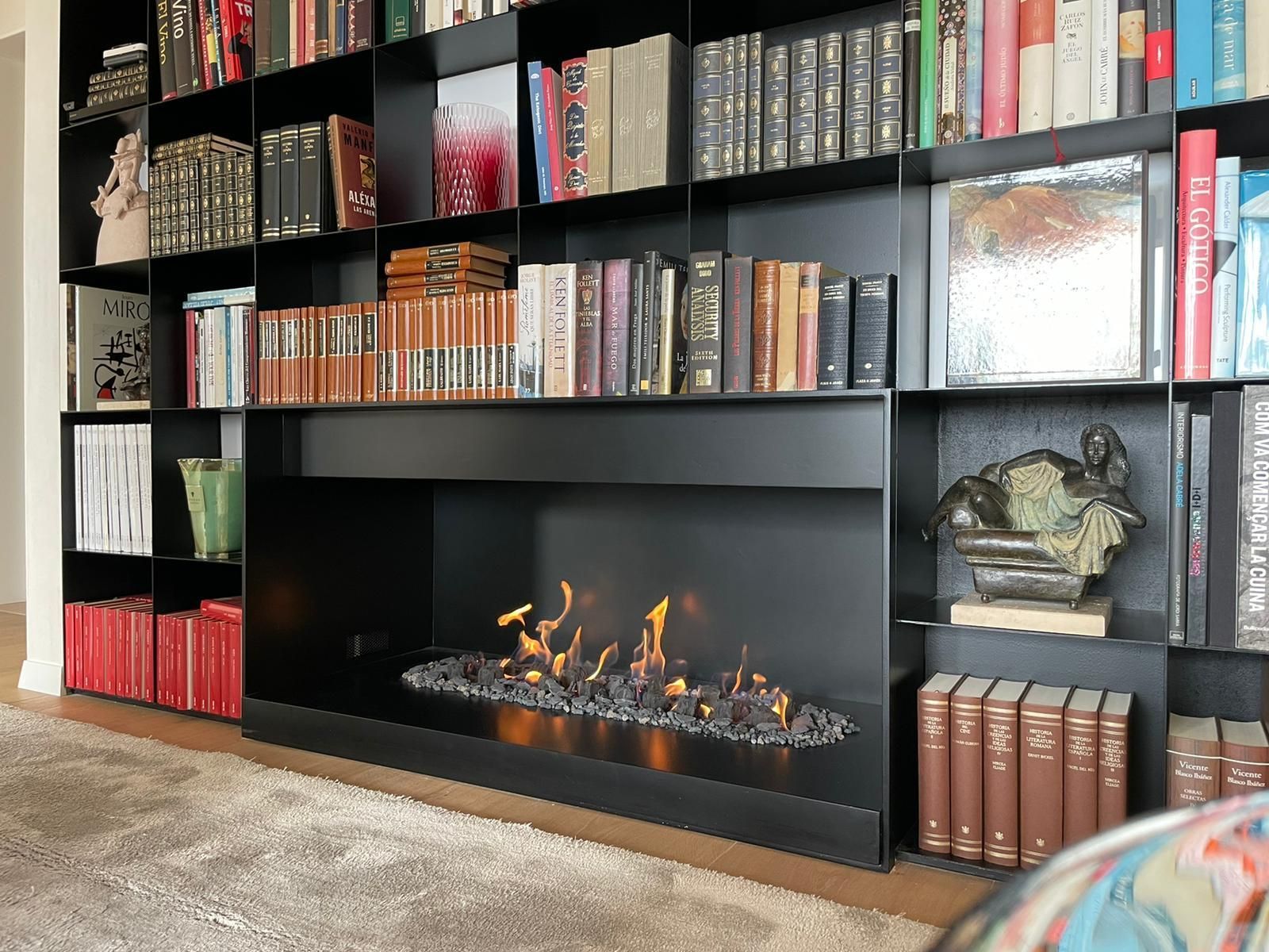 Una sala de estar con chimenea rodeada de estanterías.