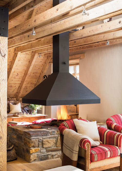 Una sala de estar con una chimenea colgando del techo.