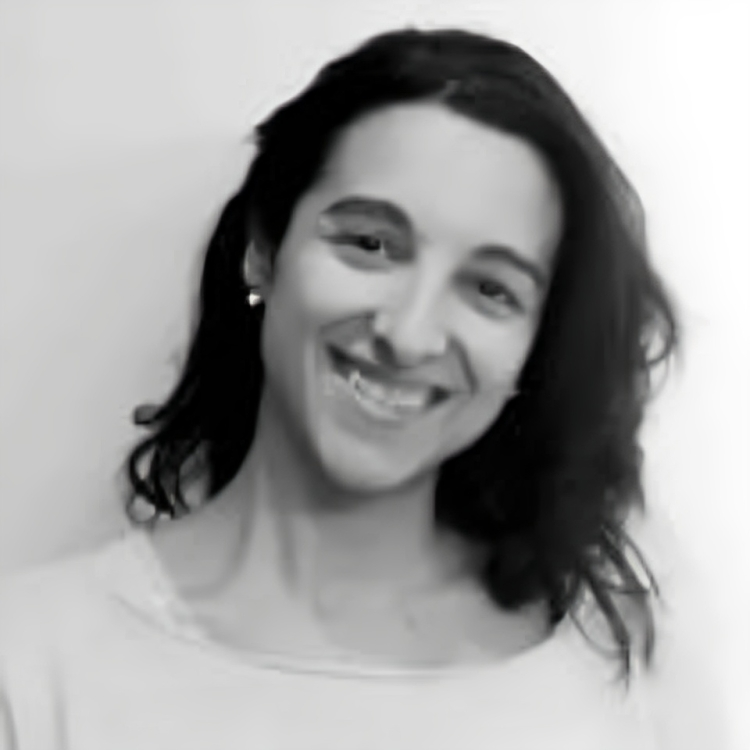 Una mujer con cabello largo sonríe en una foto en blanco y negro.