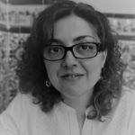 Una fotografía en blanco y negro de una mujer que lleva gafas y pendientes.