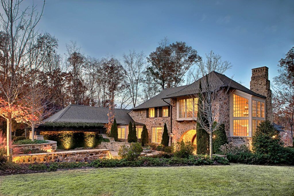 A large house with a lot of windows is surrounded by trees.