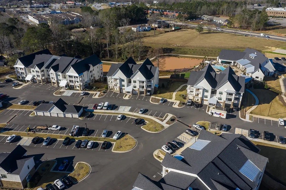 An aerial view of a residential area with houses and a parking lot.