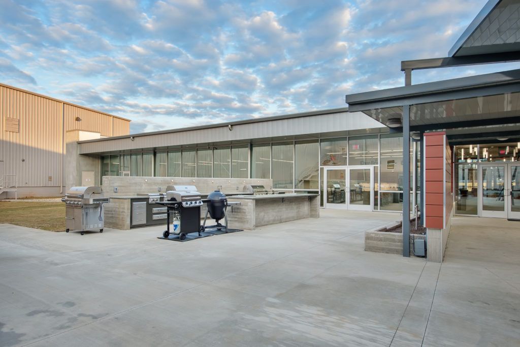 A large building with a lot of windows and grills in front of it.