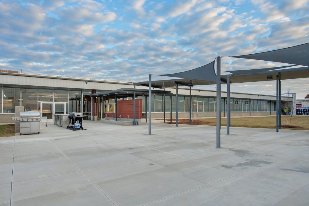 A large building under construction with a covered area in front of it.