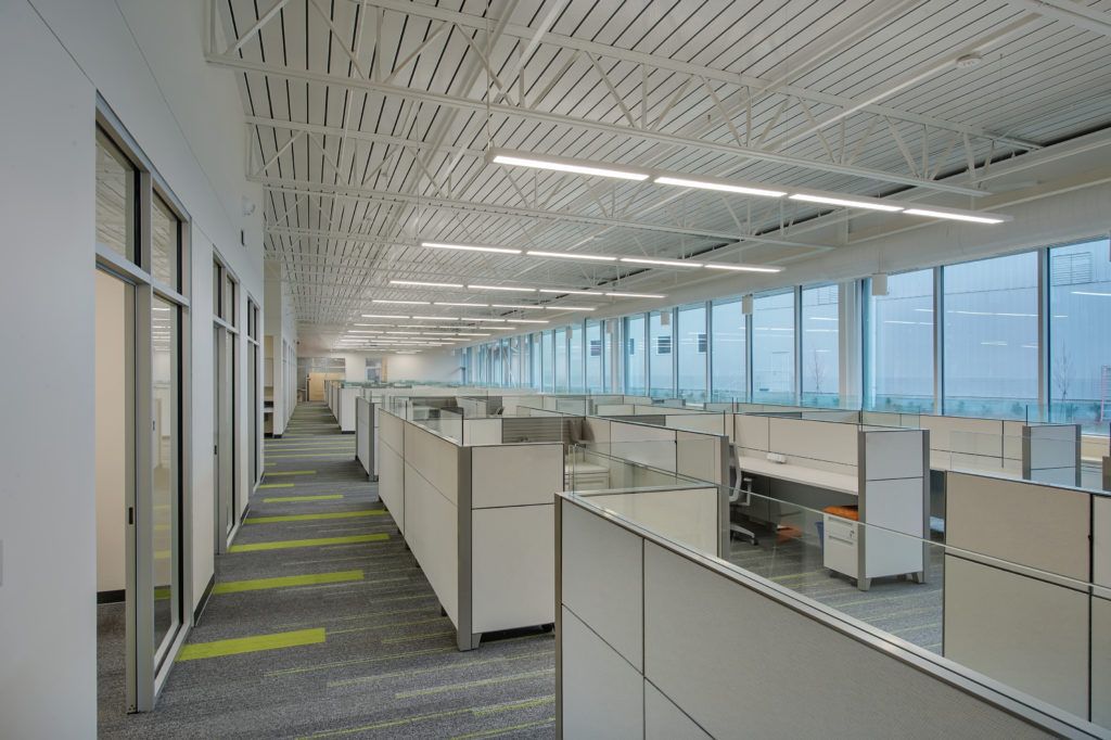 A long hallway filled with cubicles in an office building.