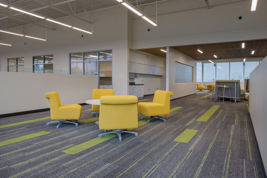 A room with yellow chairs and a table in it.