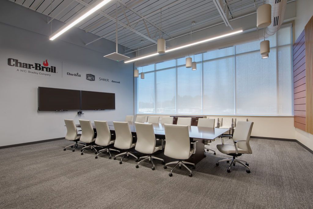 A large conference room with a long table and chairs
