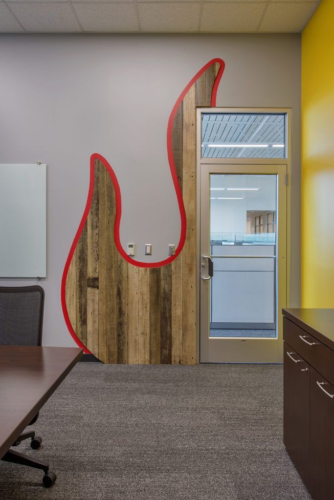 A conference room with a wooden flame painted on the wall.